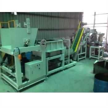 An extensive light-colored industrial machinery system, featuring a large hopper, multiple processing units, and a yellow-belted conveyor, is set up in a factory.