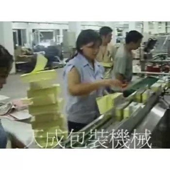 Operator overseeing the automated packaging process of notebooks.