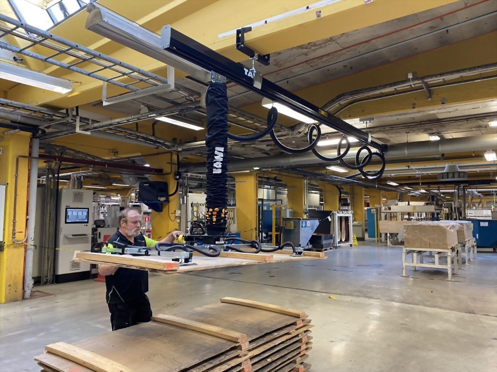 Factory worker towi kowie vacuum lifter wooden panel handling
