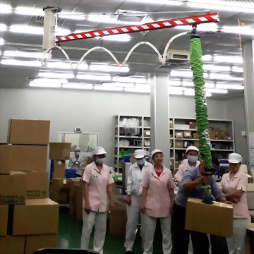 Factory workers vacuum lifter box handling