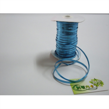 一捲淺藍色緞帶纏繞在白色捲軸上，部分緞帶展開平鋪於白色背景，右下角放置一張綠白小卡。