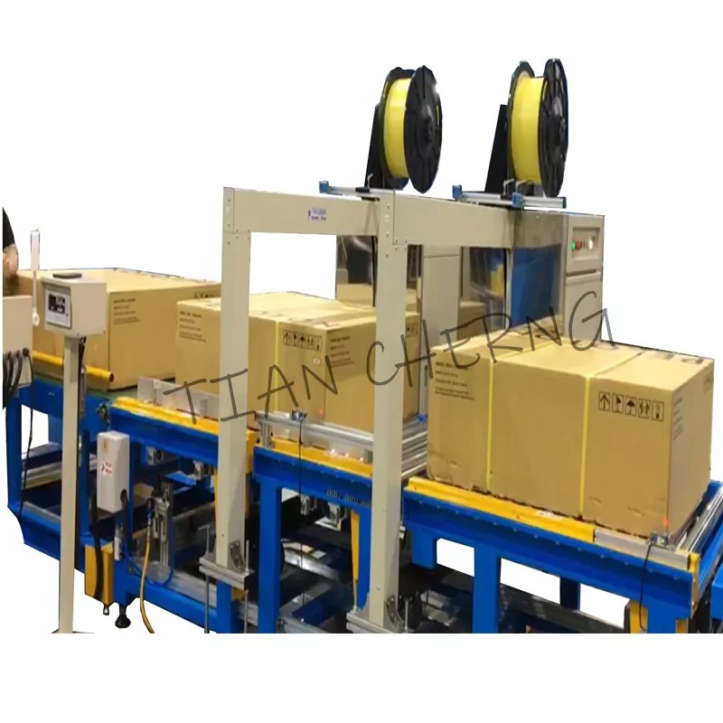 Automated cross strapping machine processing cardboard boxes on a conveyor belt