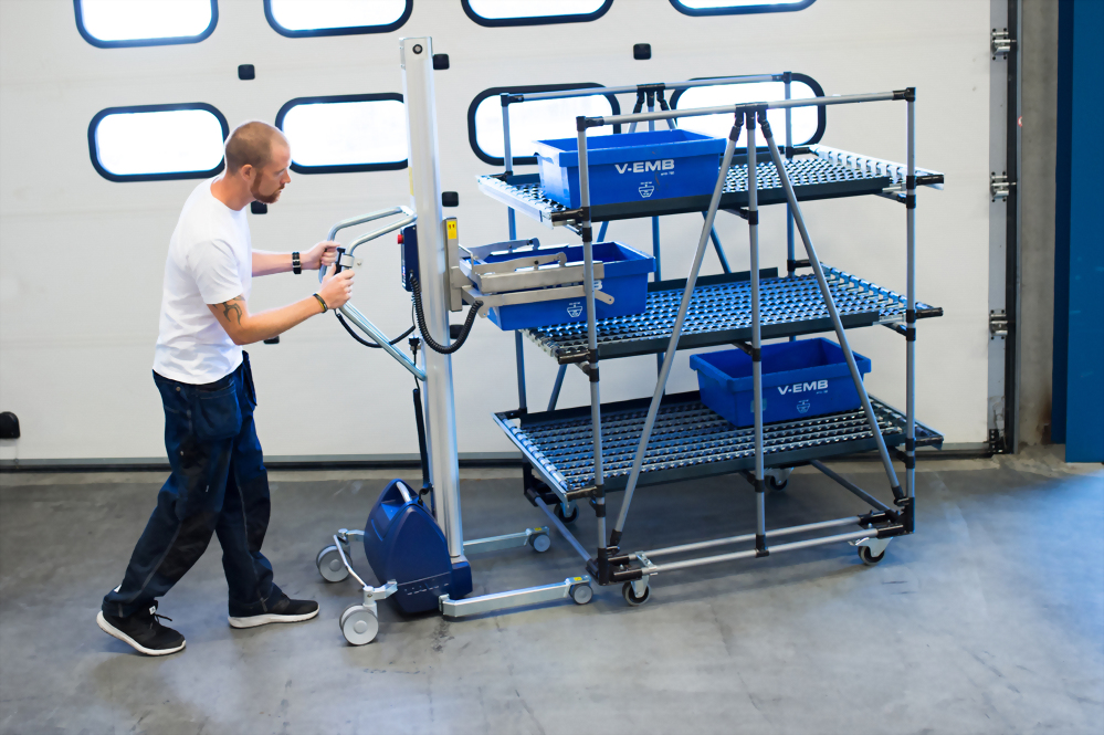 Man operating mobile lifting device warehouse shelving unit v emb