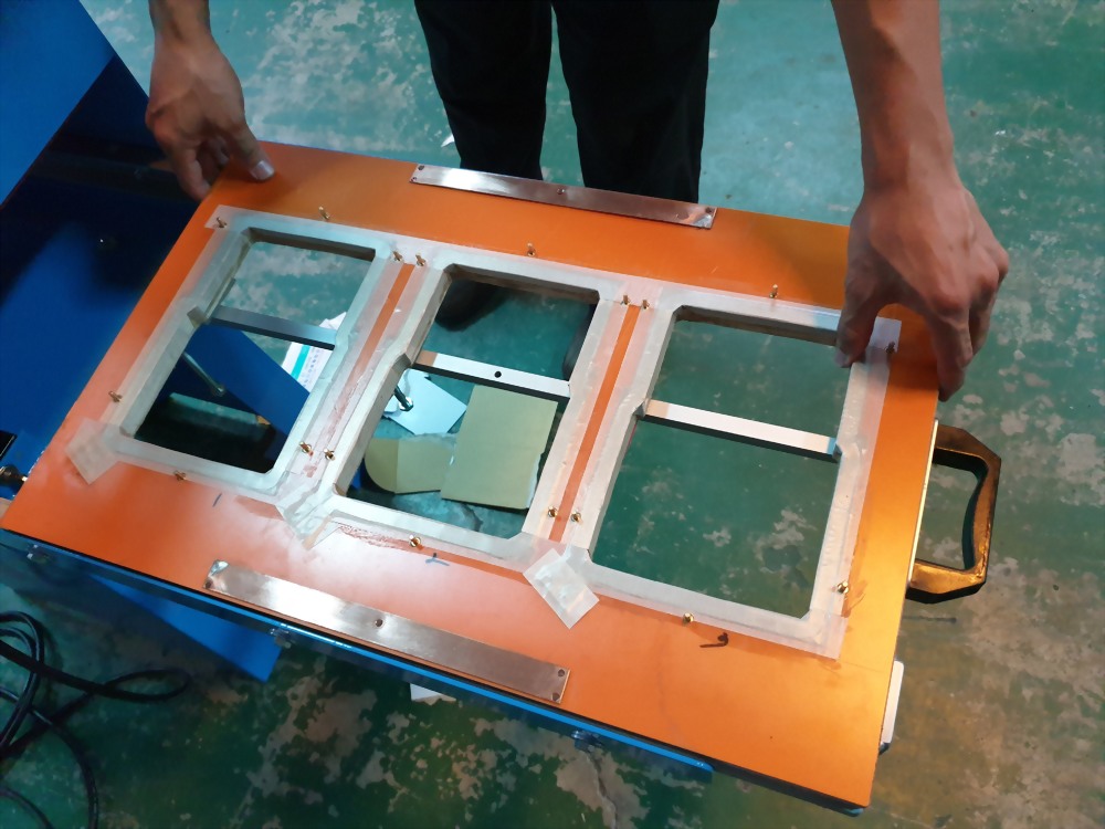 Person handling orange manufacturing jig three openings