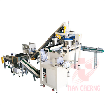 A large, multi-component automated packaging machine system with white and grey units, green conveyor belts, and yellow accents is displayed against a white background.