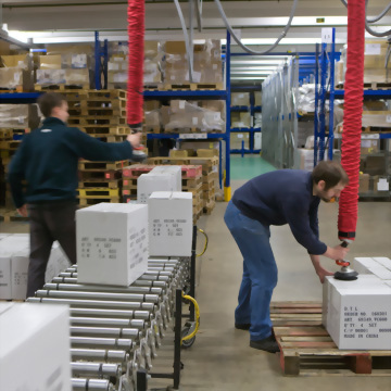 Warehouse workers vacuum lift conveyor system