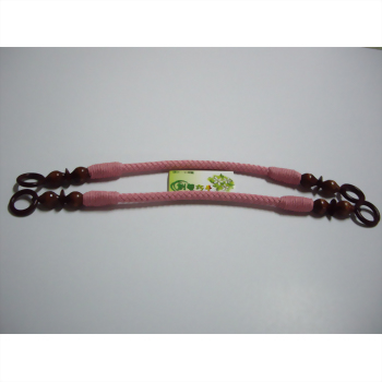 兩條粉紅色編織繩，兩端飾有深棕色木珠與木環，平放於白色背景上，中間夾著一張綠色小標籤。