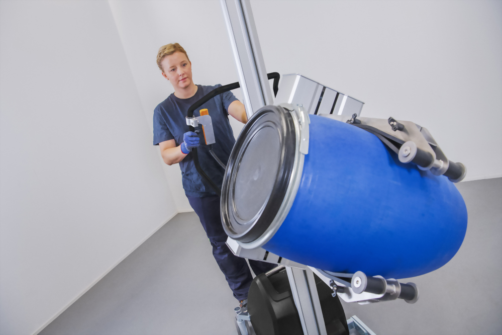 Woman operating barrel lifter blue drum