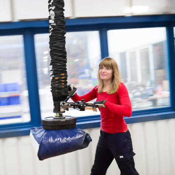 Woman operating industrial vacuum lifter bag factory
